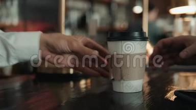 特写镜头：一个面目全非的男人用手机nfc支付银行来支付在可爱的咖啡上的费用